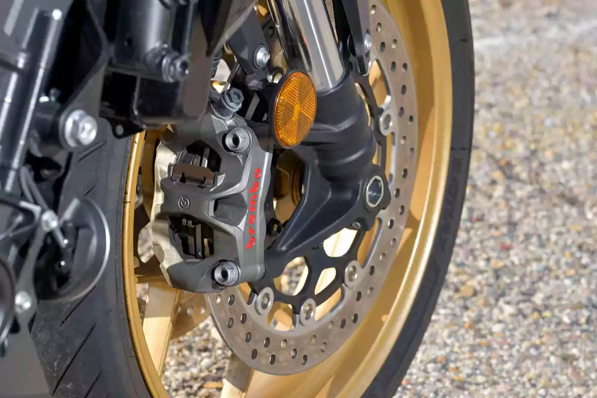 Detalle de la rueda delantera de una motocicleta con freno de disco y pinza Brembo Detalle de la rueda delantera de una motocicleta con freno de disco y pinza Brembo