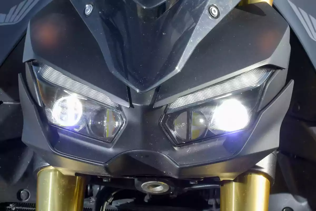 Motorcycle front with headlights on and black and gold details Motorcycle front with headlights on and black and gold details