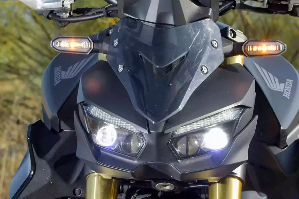Frente de una motocicleta Honda con luces encendidas y direccionales activadas Frente de una motocicleta Honda con luces encendidas y direccionales activadas