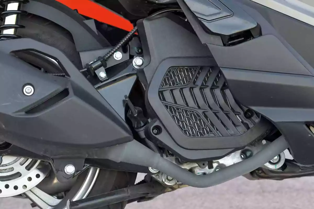 Detalle del motor y la suspensión trasera de una motocicleta con piezas de color negro y detalles metálicos Detalle del motor y la suspensión trasera de una motocicleta con piezas de color negro y detalles metálicos