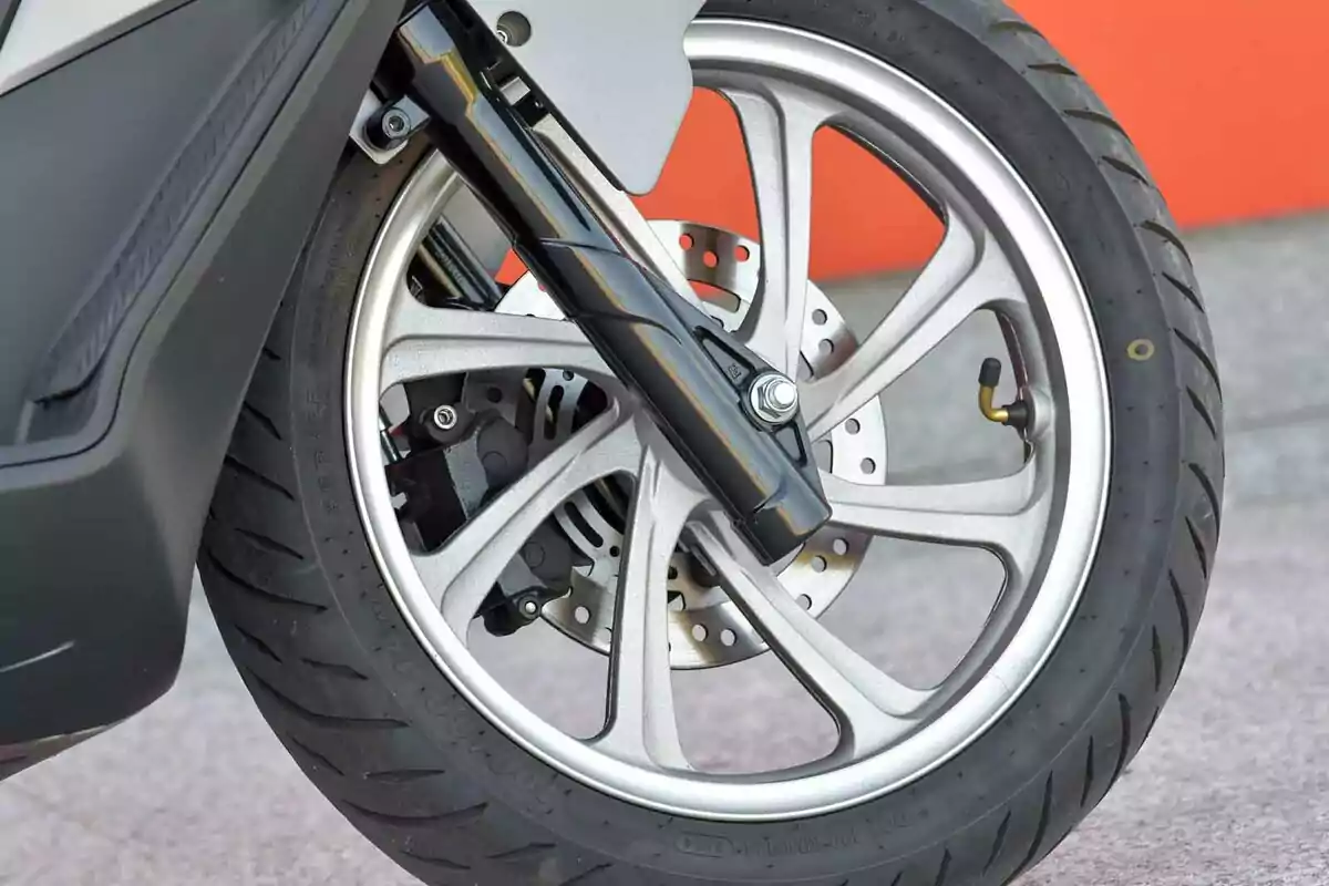 Llanta delantera de motocicleta con freno de disco y rin de aleación en primer plano Llanta delantera de motocicleta con freno de disco y rin de aleación en primer plano