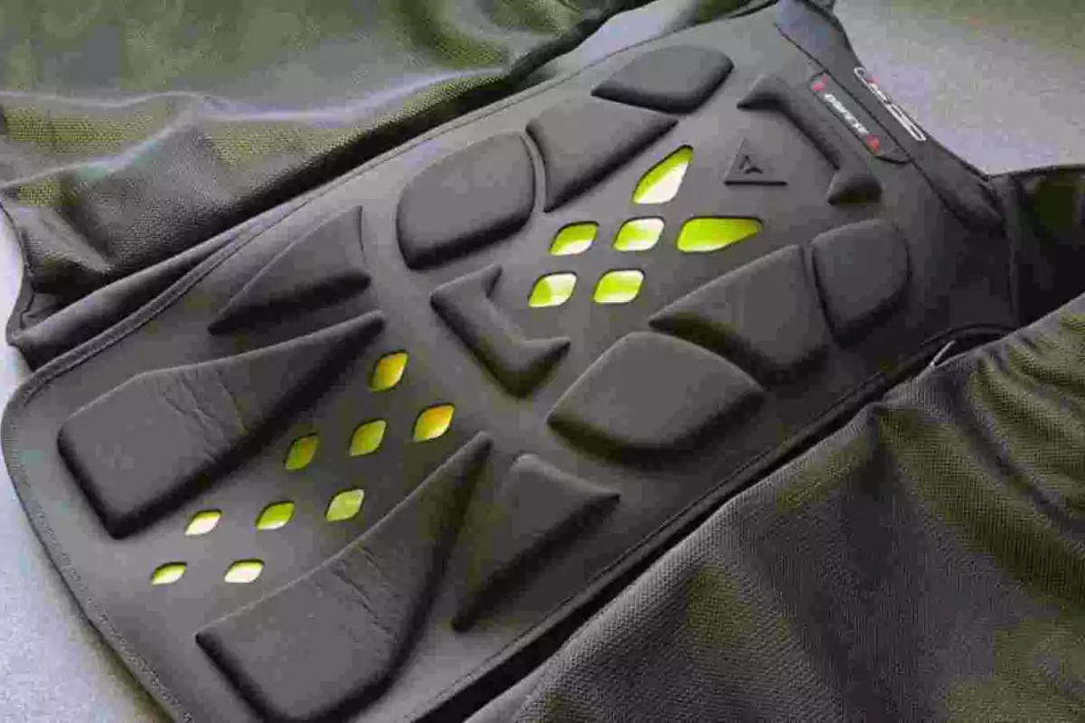 Detalle de una protección acolchada negra con orificios y fondo amarillo fluorescente sobre una tela oscura Detalle de una protección acolchada negra con orificios y fondo amarillo fluorescente sobre una tela oscura