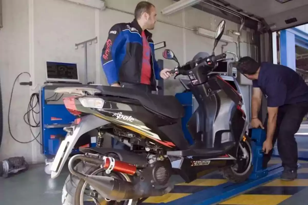 Two people are inspecting a black motorcycle at a vehicle inspection station. Two people are inspecting a black motorcycle at a vehicle inspection station.