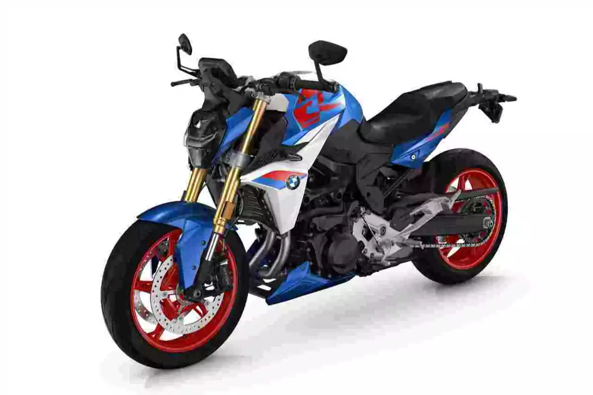 Motocicleta deportiva BMW de color azul blanco y rojo con llantas rojas y detalles dorados sobre fondo blanco Motocicleta deportiva BMW de color azul blanco y rojo con llantas rojas y detalles dorados sobre fondo blanco