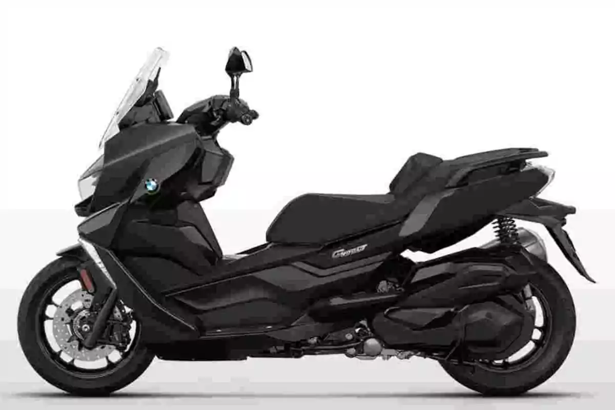 Motocicleta tipo scooter de color negro con diseño moderno y deportivo estacionada sobre un fondo claro Motocicleta tipo scooter de color negro con diseño moderno y deportivo estacionada sobre un fondo claro