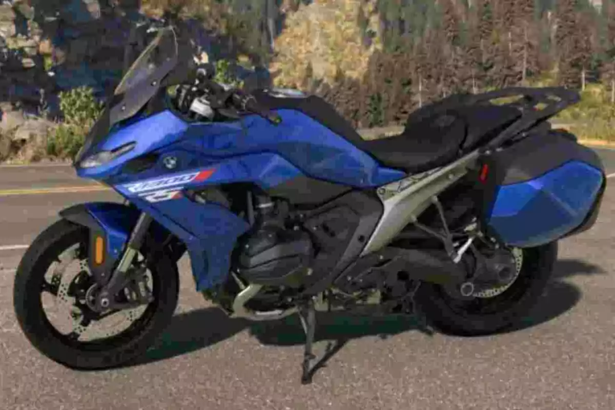Motocicleta esportiva blava estacionada en una carretera amb paisatge d’arbres i muntanyes al fons Motocicleta esportiva blava estacionada en una carretera amb paisatge d’arbres i muntanyes al fons