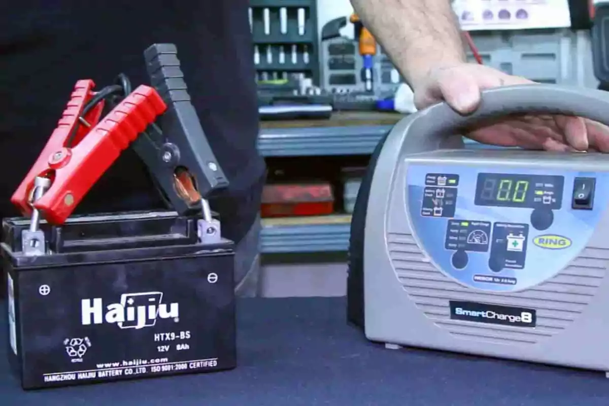 Una batería conectada a un cargador automático de baterías en un taller. Una batería conectada a un cargador automático de baterías en un taller.