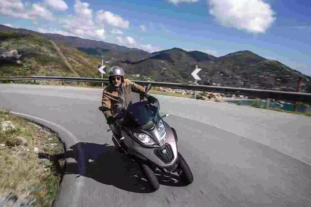 Person riding a Piaggio MP3 500 three-wheeled scooter Person riding a Piaggio MP3 500 three-wheeled scooter
