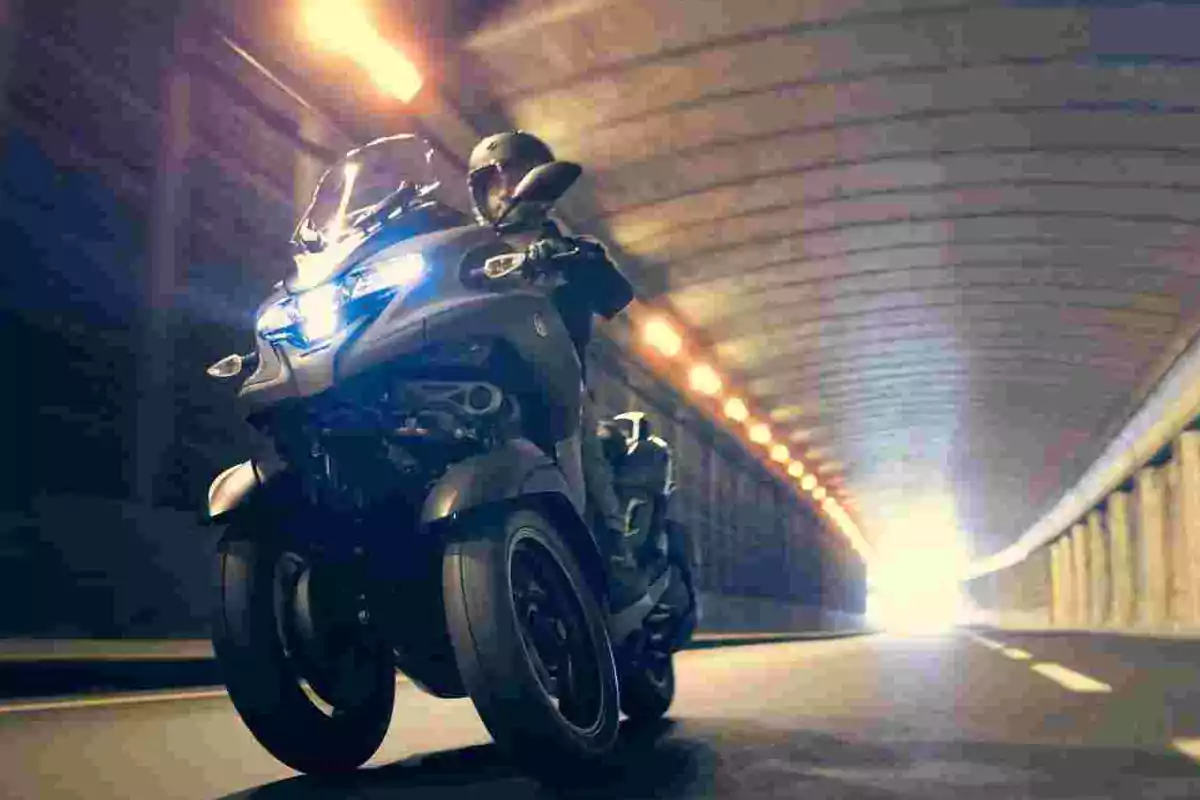 Person riding a three-wheeled motorcycle inside a lit tunnel Person riding a three-wheeled motorcycle inside a lit tunnel