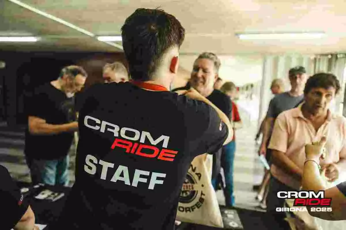 Persona del staff de Crom Ride atendiendo a varias personas en una mesa de registro durante un evento en Girona 2025 Persona del staff de Crom Ride atendiendo a varias personas en una mesa de registro durante un evento en Girona 2025
