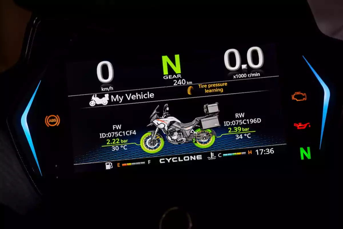Tablero digital de motocicleta mostrando información de velocidad, presión y temperatura de llantas, nivel de combustible, testigos de advertencia y una imagen de la moto en el centro de la pantalla Tablero digital de motocicleta mostrando información de velocidad, presión y temperatura de llantas, nivel de combustible, testigos de advertencia y una imagen de la moto en el centro de la pantalla