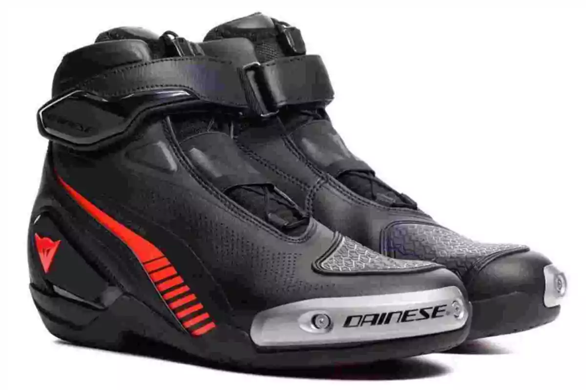 Botines de motociclista negros con detalles rojos y placas metálicas en la punta, marca Dainese Botines de motociclista negros con detalles rojos y placas metálicas en la punta, marca Dainese