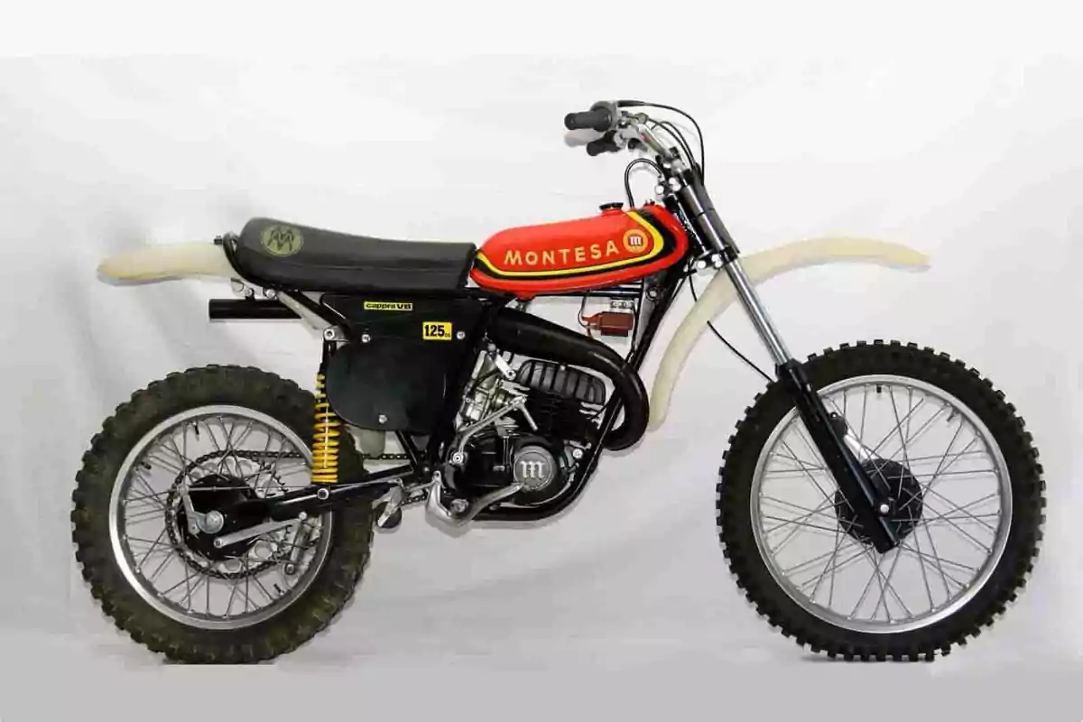Motocicleta Montesa de motocross clásica con tanque rojo y detalles en amarillo y negro sobre fondo blanco Motocicleta Montesa de motocross clásica con tanque rojo y detalles en amarillo y negro sobre fondo blanco