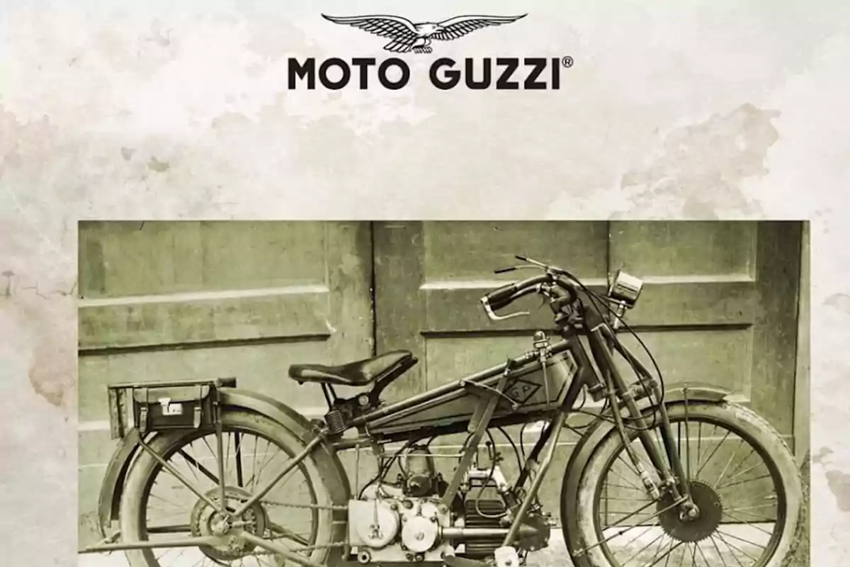 Motocicleta antigua Moto Guzzi en blanco y negro frente a una puerta de madera con el logotipo de la marca en la parte superior Motocicleta antigua Moto Guzzi en blanco y negro frente a una puerta de madera con el logotipo de la marca en la parte superior