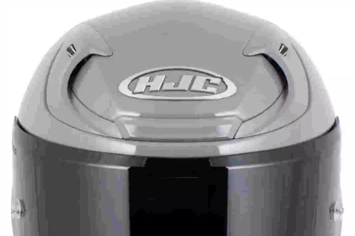 Casco de motocicleta gris con visera oscura y logotipo HJC en la parte superior Casco de motocicleta gris con visera oscura y logotipo HJC en la parte superior