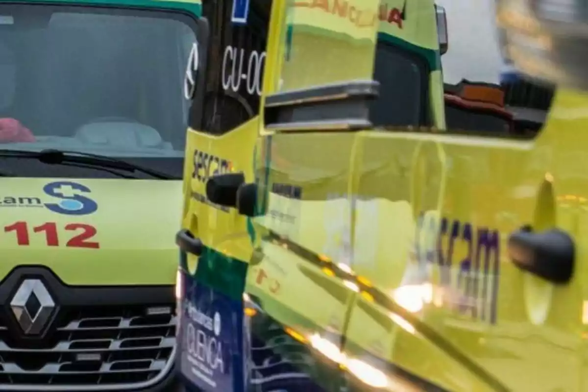 Ambulancias amarillas estacionadas una junto a la otra con el número de emergencias 112 visible en el parabrisas de una de ellas Ambulancias amarillas estacionadas una junto a la otra con el número de emergencias 112 visible en el parabrisas de una de ellas