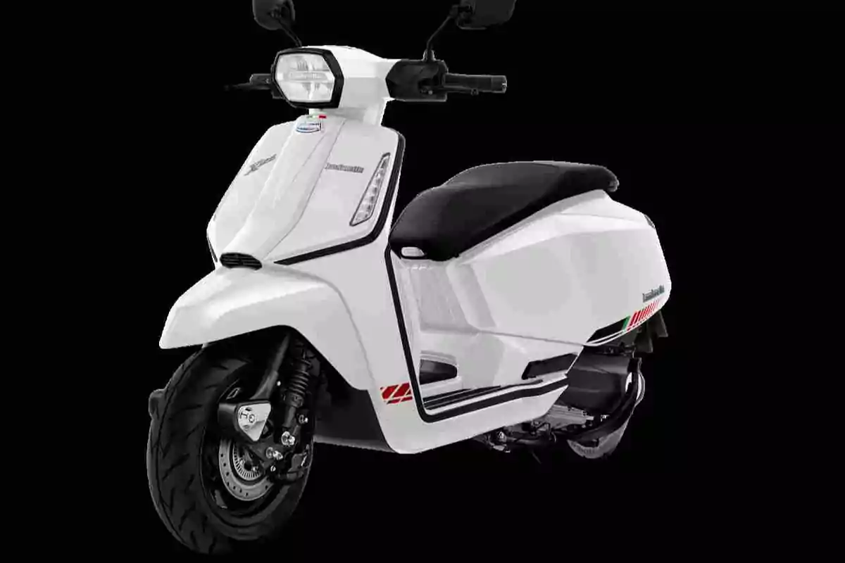 Motocicleta tipo scooter de color blanco con asiento negro sobre fondo negro Motocicleta tipo scooter de color blanco con asiento negro sobre fondo negro