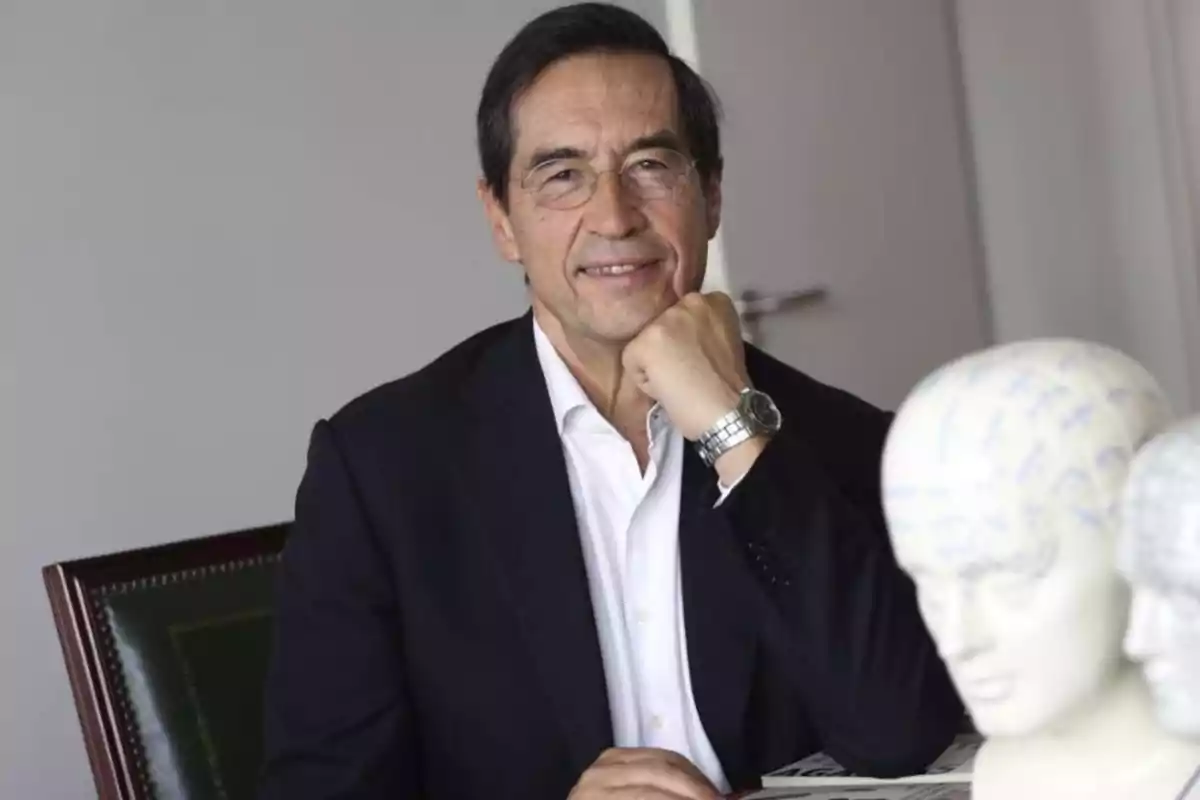 Mario Alonso Puig o sentado en una oficina, apoyando el mentón en su mano, con bustos de modelos anatómicos en primer plano. Mario Alonso Puig o sentado en una oficina, apoyando el mentón en su mano, con bustos de modelos anatómicos en primer plano.