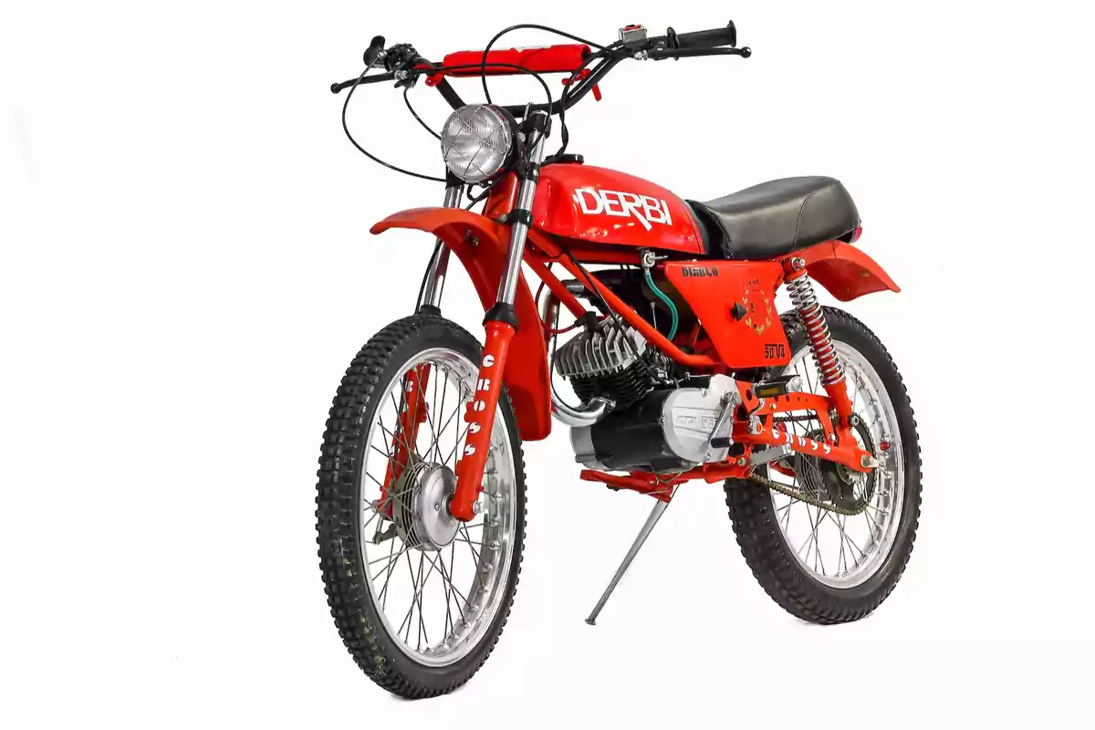 Classic-style red Derbi motorcycle with knobby tires and black seat on a white background