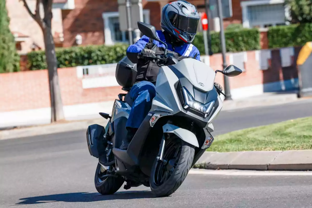 Person riding a gray motorcycle on an urban street during the day