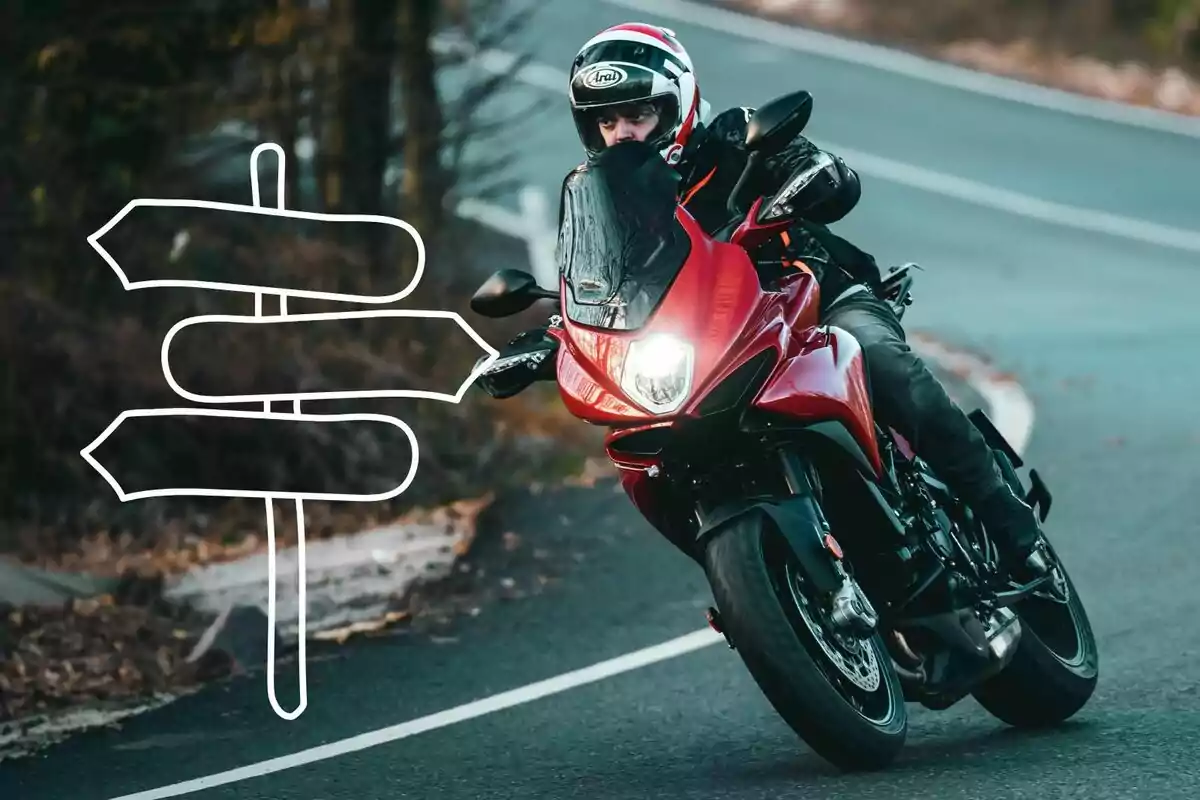 Persona conduciendo una motocicleta roja en una carretera curva con un dibujo de señales de dirección al lado izquierdo. Persona conduciendo una motocicleta roja en una carretera curva con un dibujo de señales de dirección al lado izquierdo.