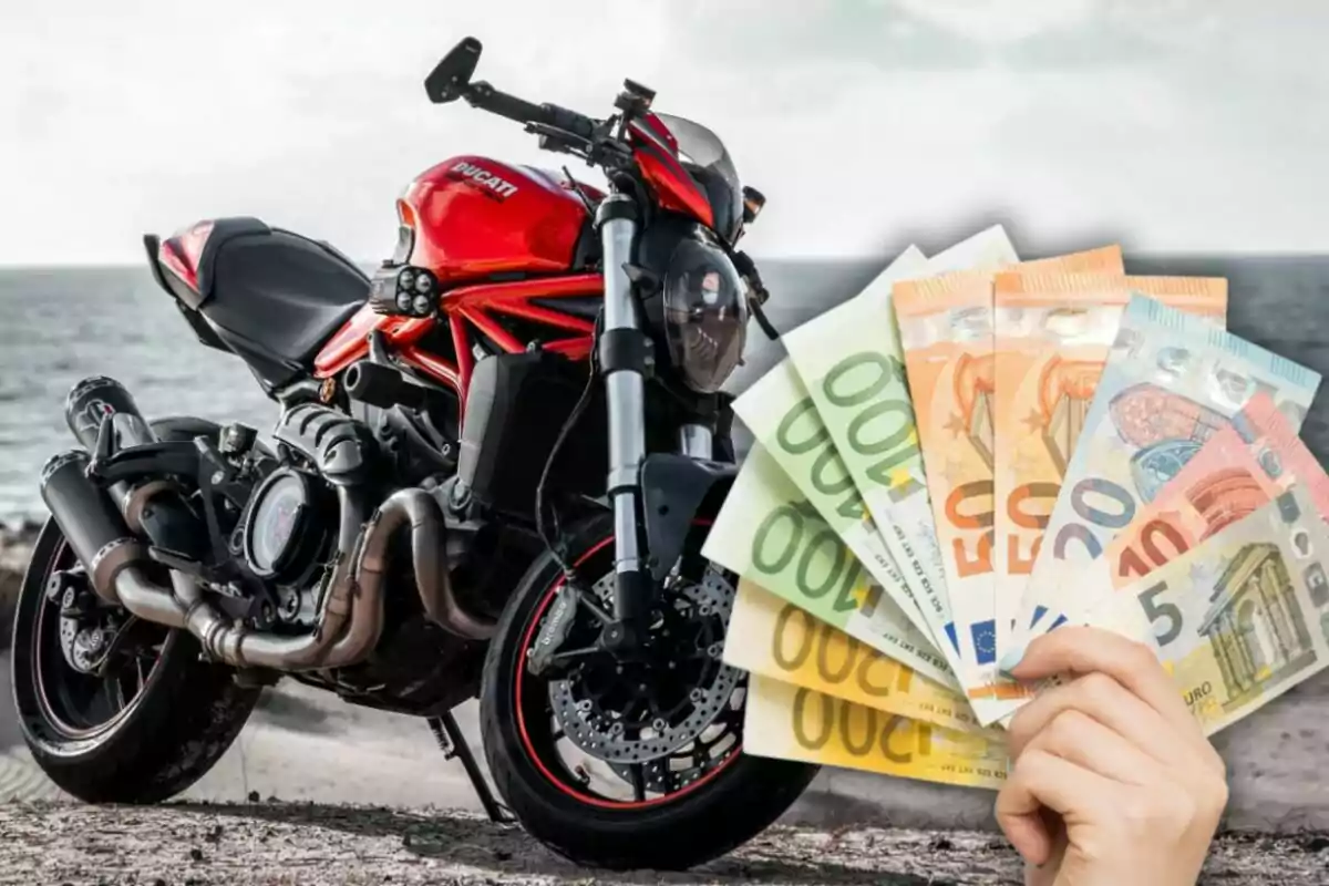 Motocicleta deportiva roja estacionada junto al mar con una mano sosteniendo varios billetes de euro en primer plano