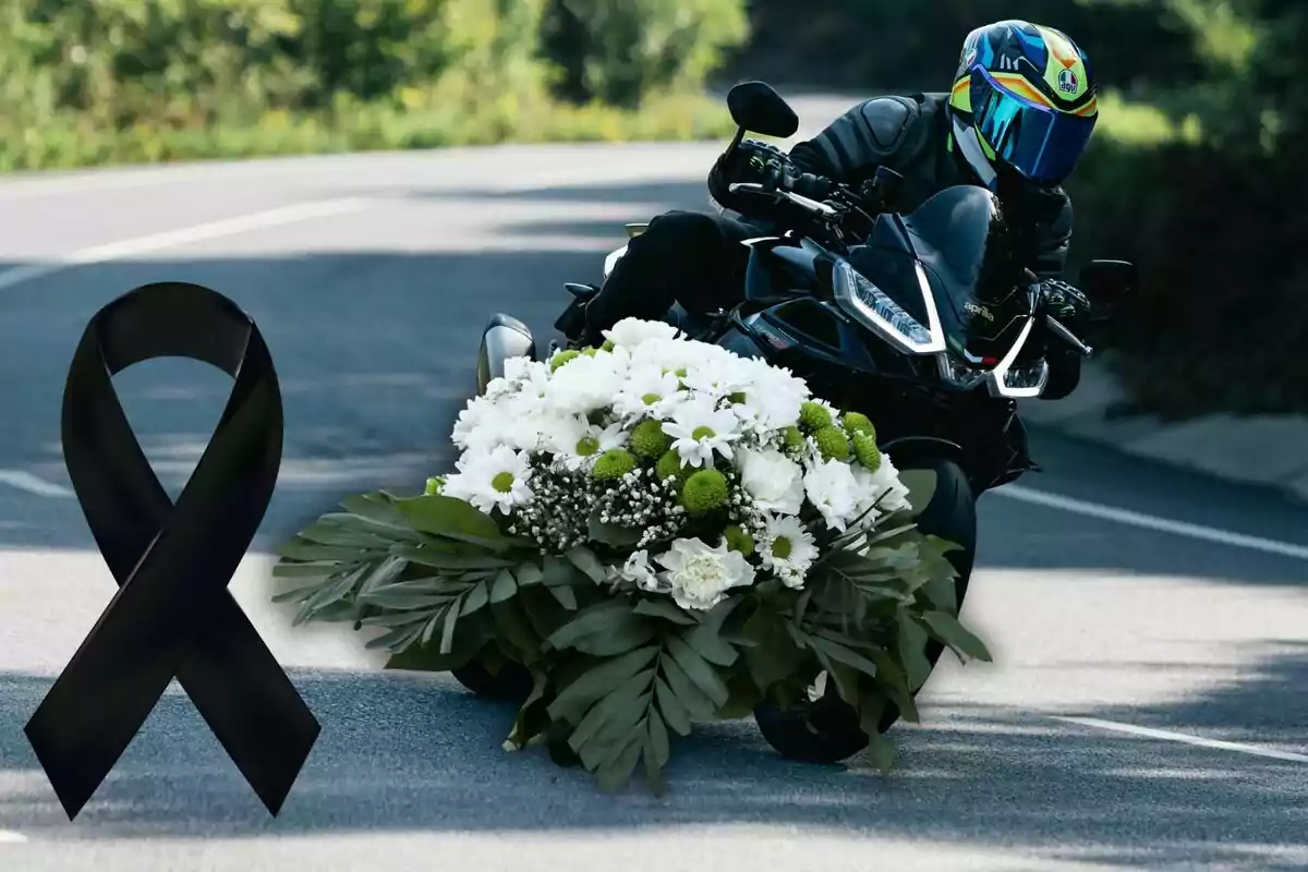 Motociclista con casco y traje negro conduce una moto decorada con un gran arreglo floral blanco y verde, junto a un listón negro de luto en una carretera. Motociclista con casco y traje negro conduce una moto decorada con un gran arreglo floral blanco y verde, junto a un listón negro de luto en una carretera.