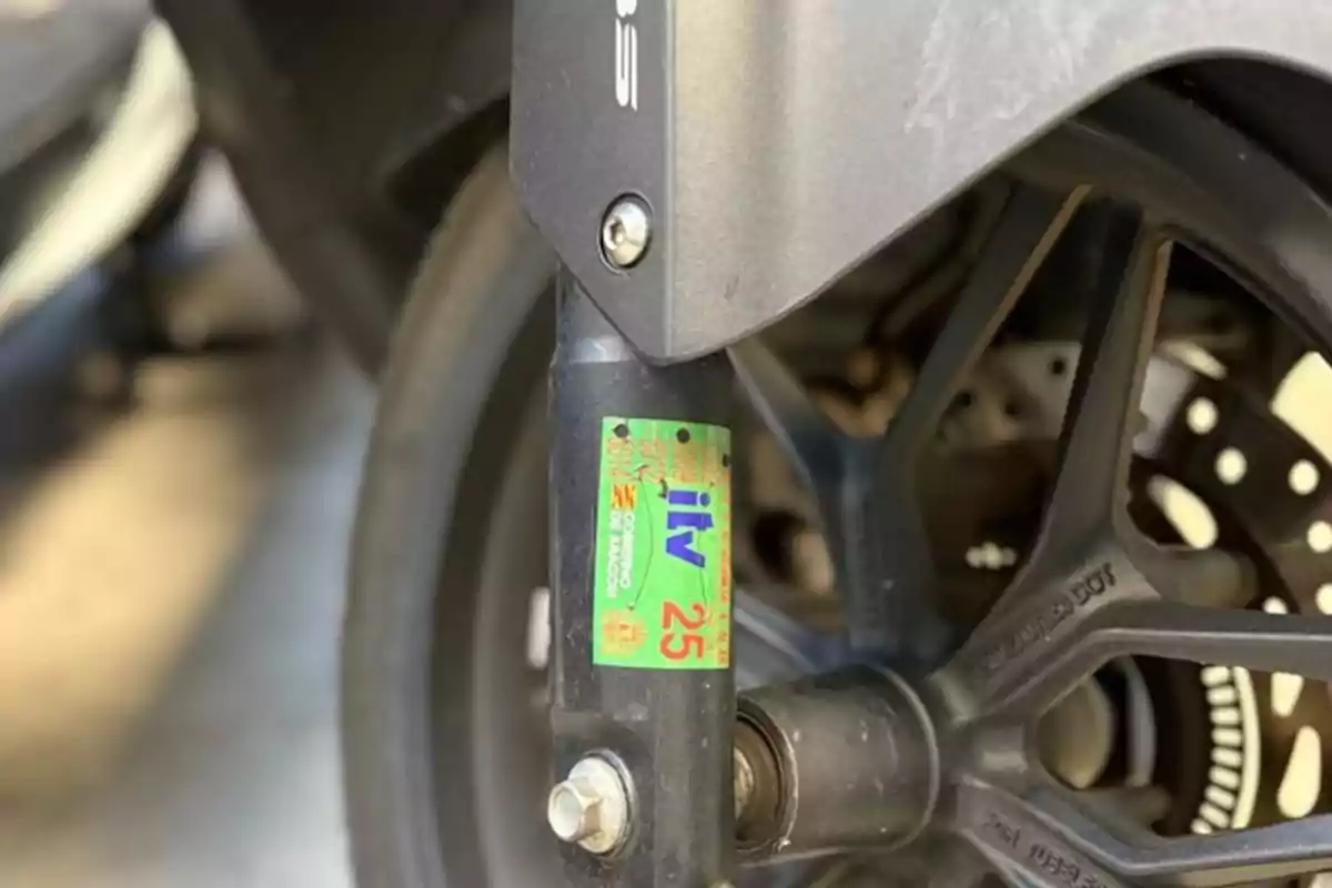 Vehicle inspection sticker affixed to the fork of a motorcycle with the rear wheel in the background Vehicle inspection sticker affixed to the fork of a motorcycle with the rear wheel in the background