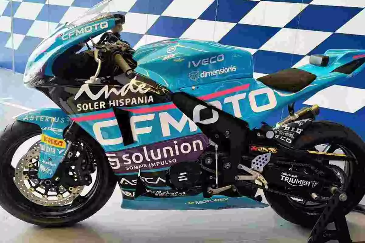 Motocicleta de carreras azul con múltiples logotipos de patrocinadores y fondo de cuadros azules y blancos Motocicleta de carreras azul con múltiples logotipos de patrocinadores y fondo de cuadros azules y blancos