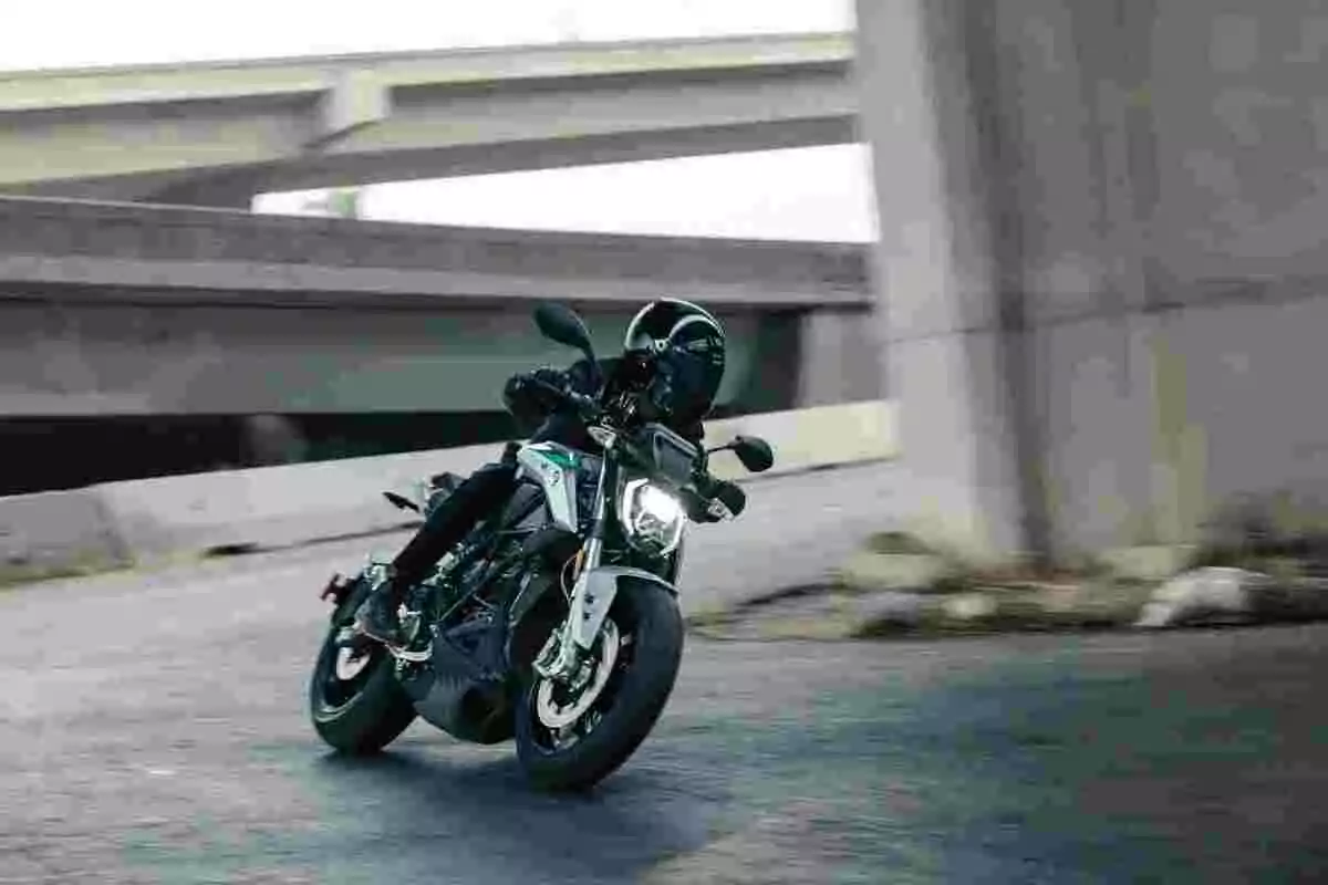 Persona conduciendo una motocicleta deportiva en una curva bajo un paso elevado de concreto Persona conduciendo una motocicleta deportiva en una curva bajo un paso elevado de concreto