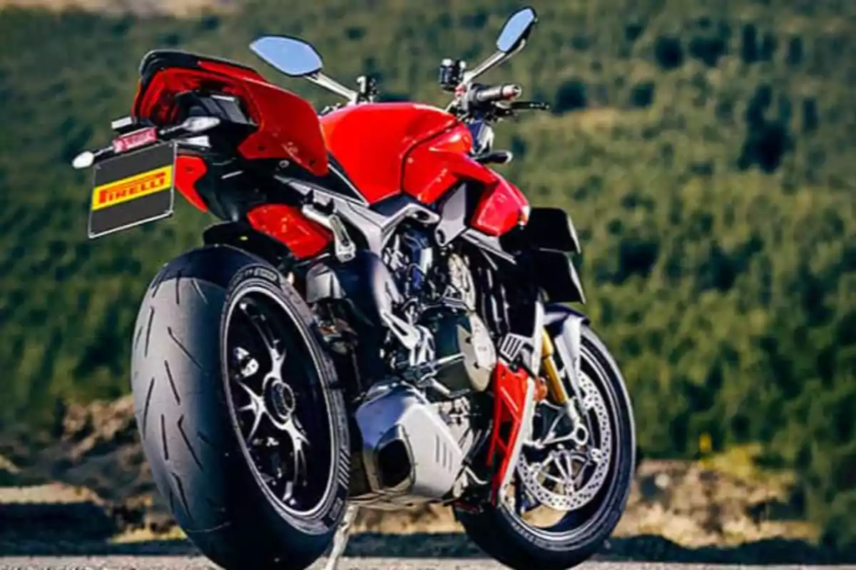 Red sport motorcycle parked on a road with a background of trees. Red sport motorcycle parked on a road with a background of trees.