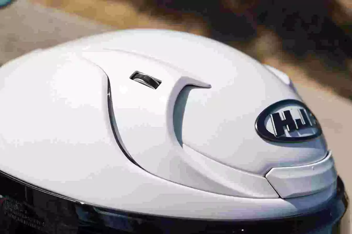 Casco de motocicleta blanco con ventilación y logotipo HJC en la parte superior Casco de motocicleta blanco con ventilación y logotipo HJC en la parte superior