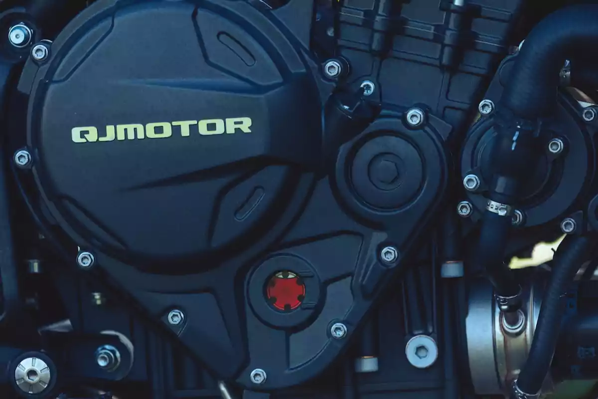 Detalle del motor de una motocicleta QJMotor con tornillos y mangueras visibles Detalle del motor de una motocicleta QJMotor con tornillos y mangueras visibles