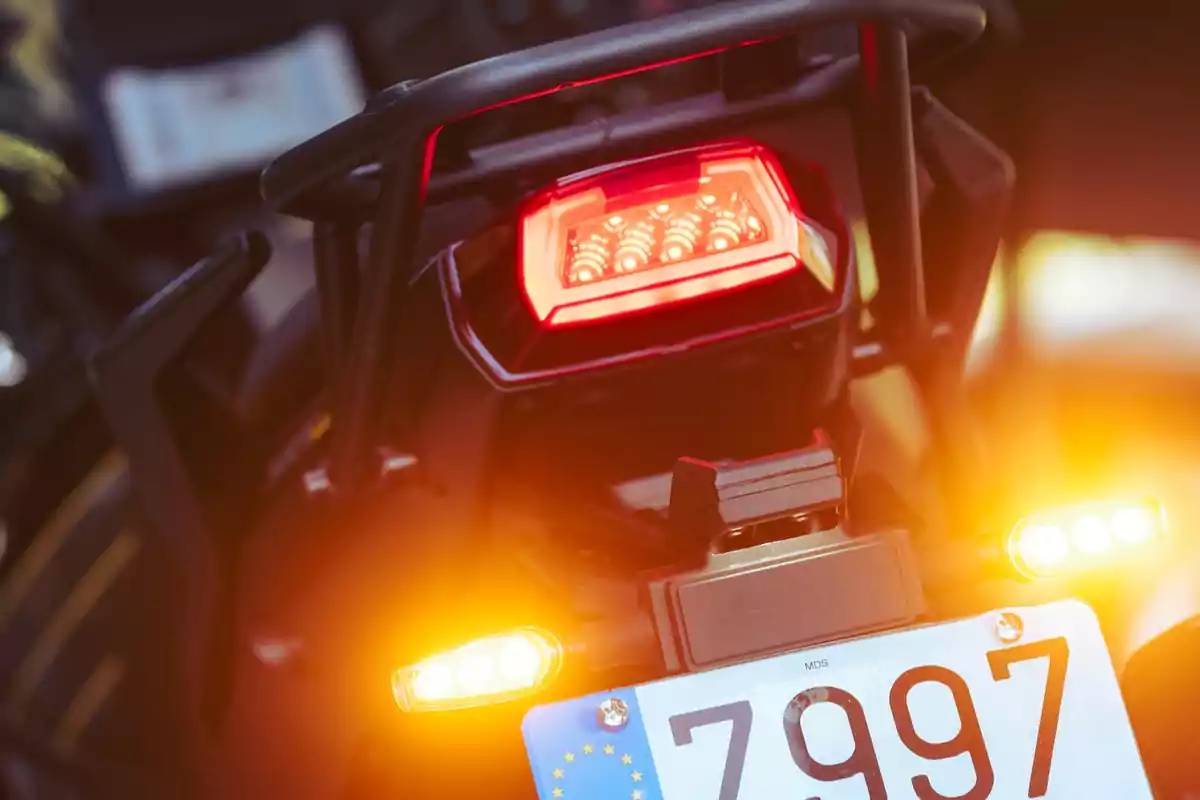 Vista trasera de una motocicleta con la luz de freno encendida y la matrícula visible Vista trasera de una motocicleta con la luz de freno encendida y la matrícula visible