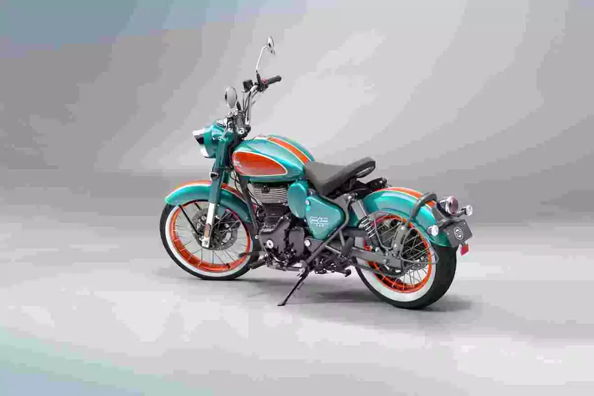 Motocicleta clàssica de color turquesa amb detalls taronja i rodes amb cercles taronja sobre un fons gris clar Motocicleta clàssica de color turquesa amb detalls taronja i rodes amb cercles taronja sobre un fons gris clar