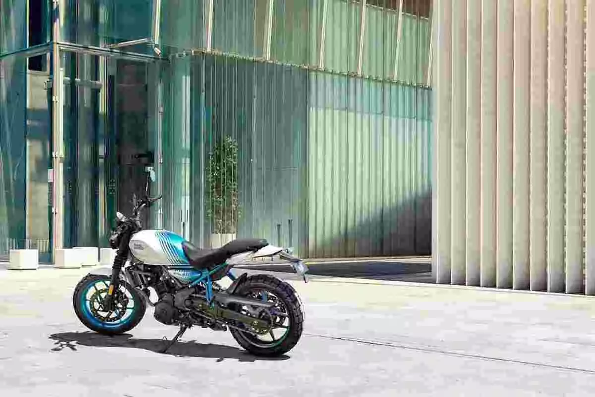 Motocicleta estacionada frente a un edificio moderno de vidrio y concreto en un día soleado Motocicleta estacionada frente a un edificio moderno de vidrio y concreto en un día soleado
