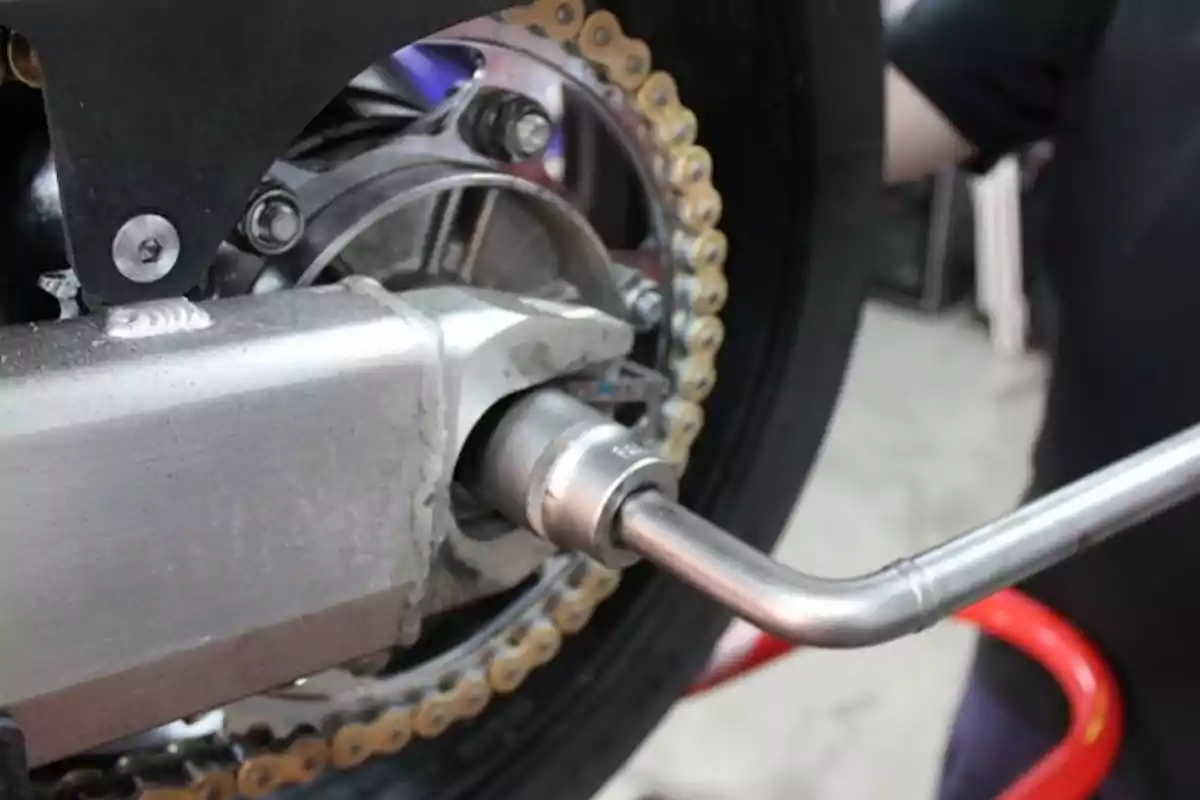 Clau de tub ajustant la femella de l’eix del darrere d’una motocicleta Clau de tub ajustant la femella de l’eix del darrere d’una motocicleta