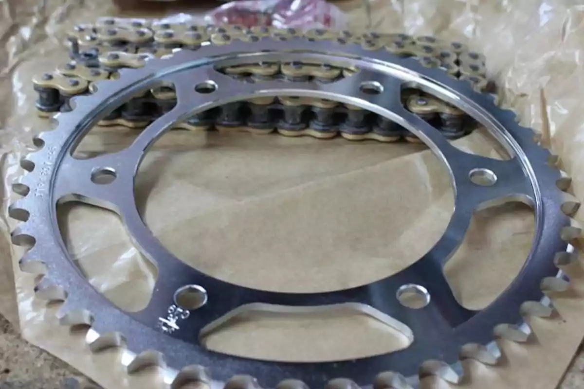Engranatge metàl·lic i cadena de bicicleta sobre paper marró Engranatge metàl·lic i cadena de bicicleta sobre paper marró