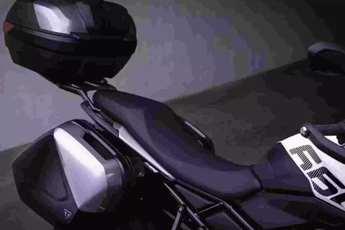 Motocicleta negra con maletas laterales y baúl trasero en un entorno oscuro Motocicleta negra con maletas laterales y baúl trasero en un entorno oscuro