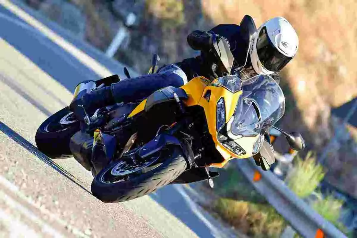 Persona conduciendo una motocicleta deportiva amarilla en una carretera curva Persona conduciendo una motocicleta deportiva amarilla en una carretera curva