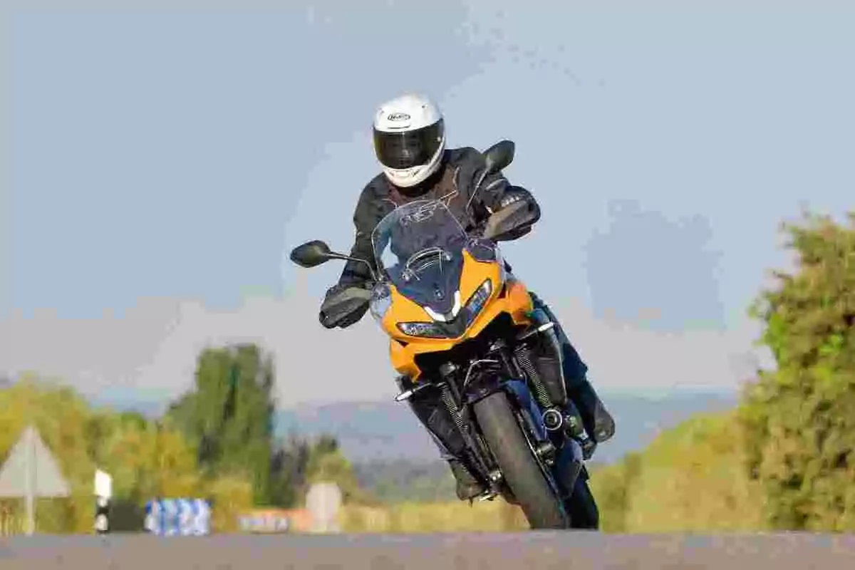Persona conduciendo una motocicleta deportiva amarilla en una carretera al aire libre Persona conduciendo una motocicleta deportiva amarilla en una carretera al aire libre