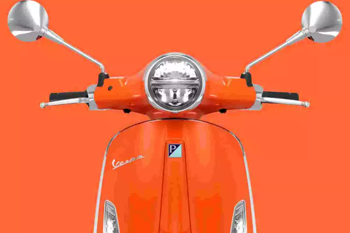Motocicleta tipo Vespa de color naranja vista de frente sobre un fondo naranja Motocicleta tipo Vespa de color naranja vista de frente sobre un fondo naranja