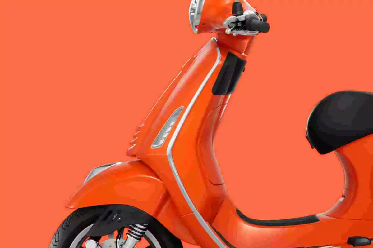 Motocicleta tipo scooter de color naranja sobre un fondo del mismo tono Motocicleta tipo scooter de color naranja sobre un fondo del mismo tono