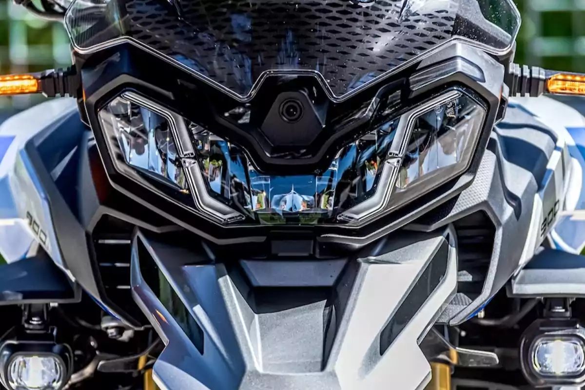 Frontal de una motocicleta moderna con faros LED encendidos y detalles en color negro y gris Frontal de una motocicleta moderna con faros LED encendidos y detalles en color negro y gris
