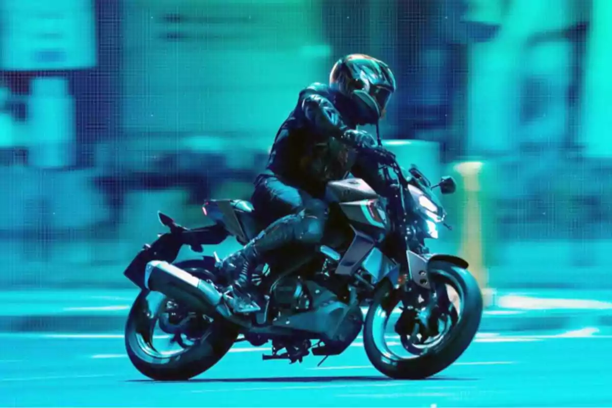 Persona con casco y ropa de protección conduciendo una motocicleta deportiva en una ciudad iluminada con luces azules