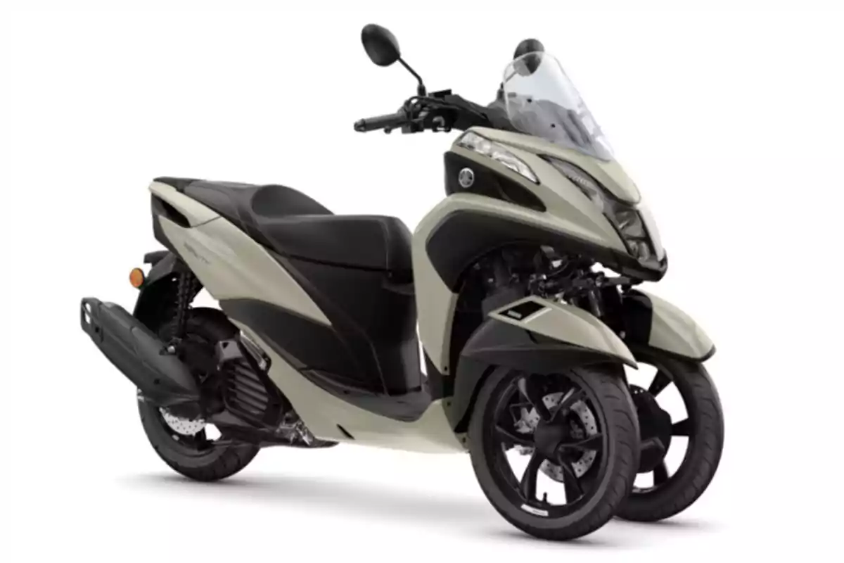 Motocicleta tipo scooter de tres ruedas color beige con parabrisas y diseño moderno sobre fondo blanco