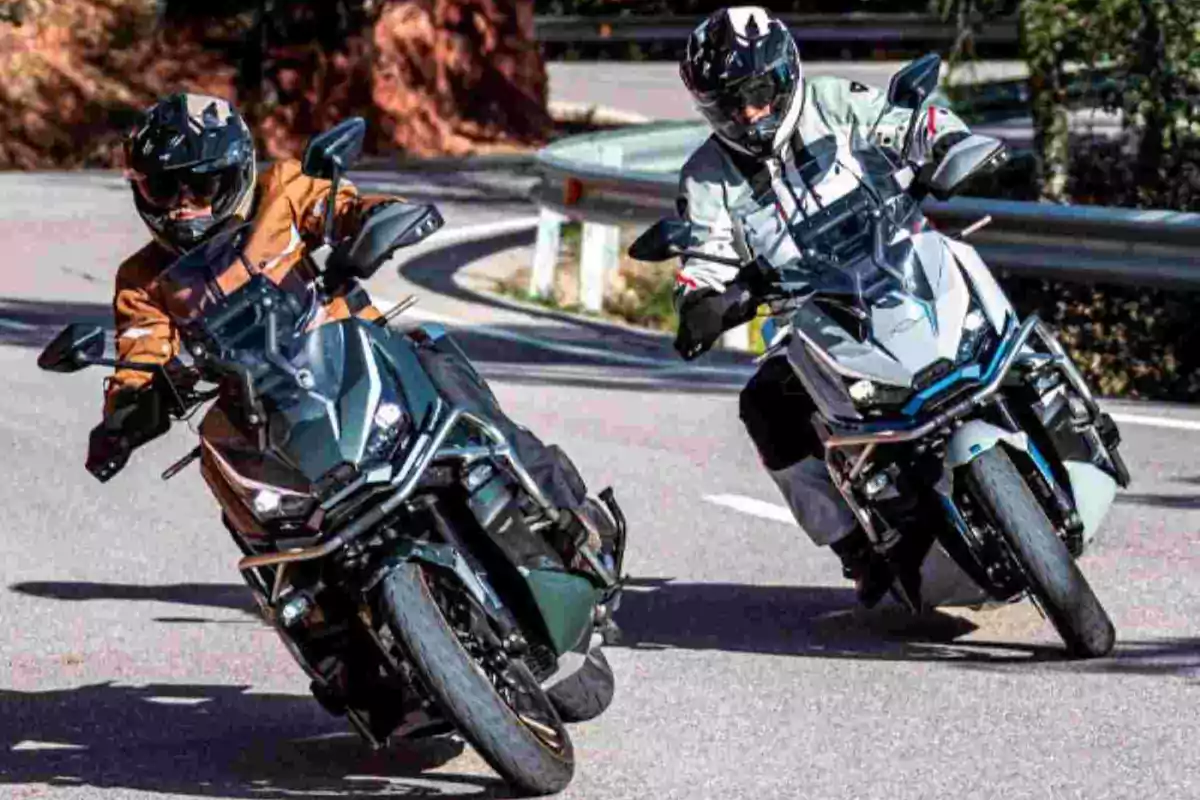 Dues persones amb equip de protecció condueixen motocicletes esportives per una carretera amb corbes. Dues persones amb equip de protecció condueixen motocicletes esportives per una carretera amb corbes.