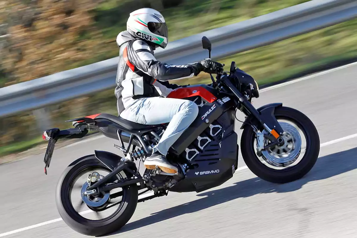 Persona conduciendo una motocicleta eléctrica Brammo Empulse en una carretera con fondo desenfocado Persona conduciendo una motocicleta eléctrica Brammo Empulse en una carretera con fondo desenfocado