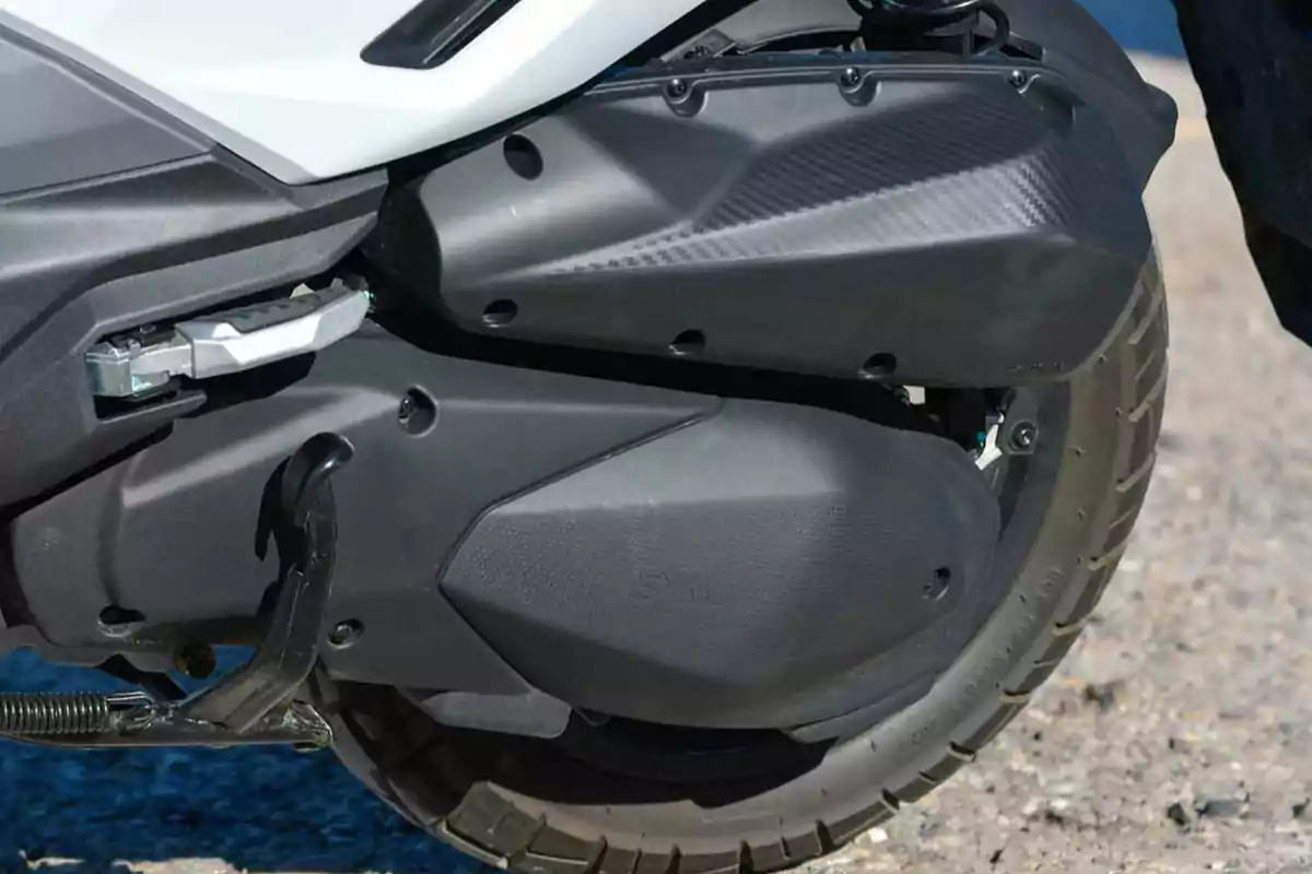 Rueda trasera y escape de una motocicleta sobre el asfalto Rueda trasera y escape de una motocicleta sobre el asfalto