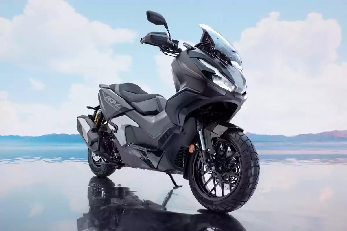 Motocicleta negra de estilo deportivo estacionada sobre una superficie reflectante con un paisaje de cielo azul y montañas al fondo Motocicleta negra de estilo deportivo estacionada sobre una superficie reflectante con un paisaje de cielo azul y montañas al fondo